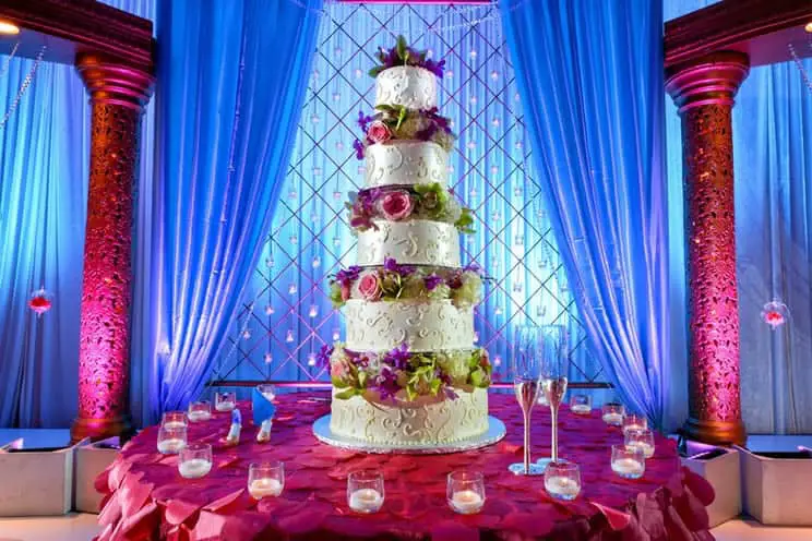 image of a tall tiered wedding cake at indian wedding