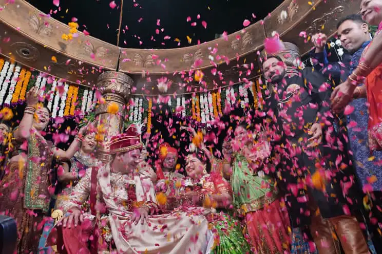 Flowers being thrown on Hindu groom and bride at Indian wedding