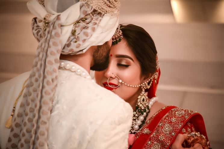 Hindu groom kissing Hindu bride