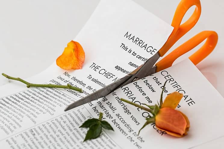 Photo of scissors cutting up marriage certificate and rose.