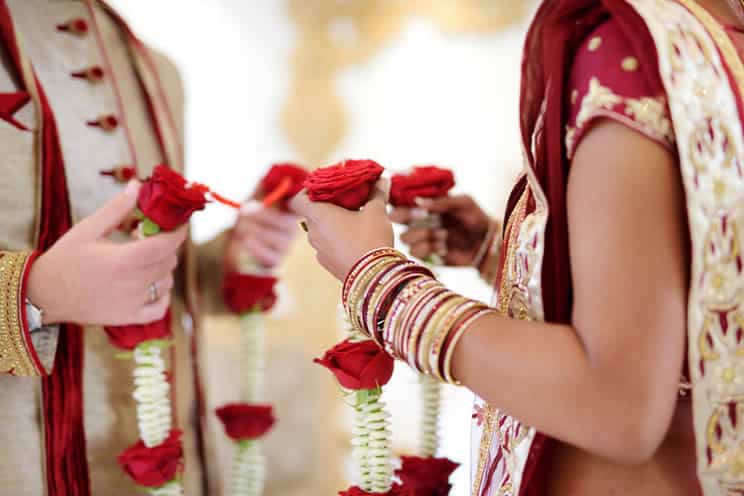 Jain couple holding flowers at wedding ceremony